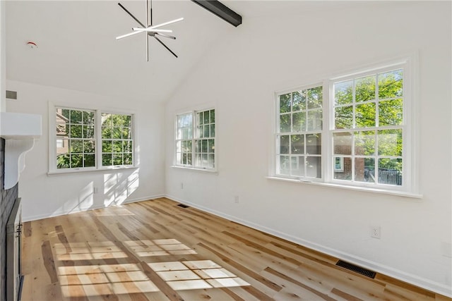 unfurnished living room featuring light hardwood / wood-style floors, high vaulted ceiling, and a notable chandelier