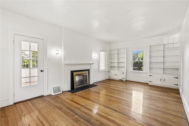 unfurnished living room with light hardwood / wood-style flooring and plenty of natural light