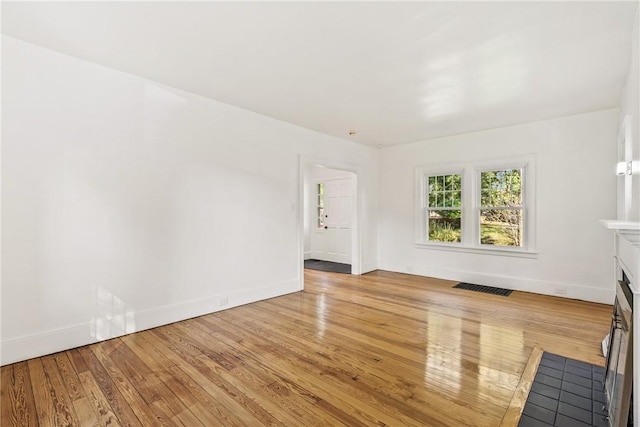 unfurnished living room with light wood-type flooring and a fireplace