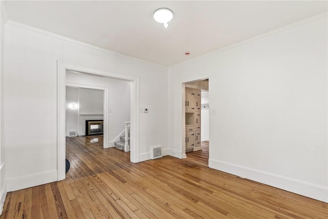 empty room featuring ornamental molding and hardwood / wood-style flooring