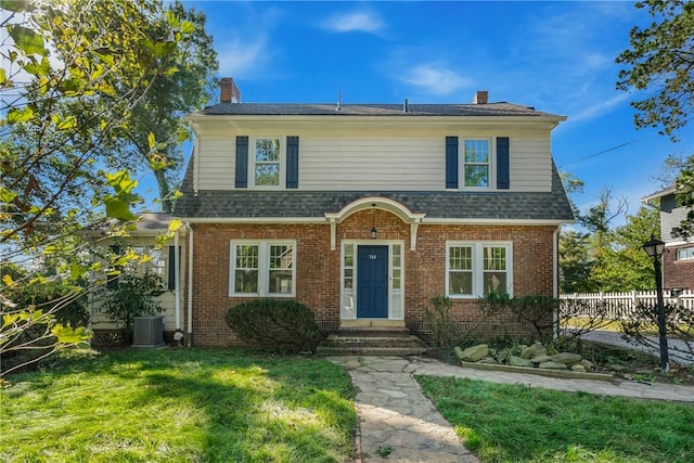 view of front of house with central AC and a front lawn