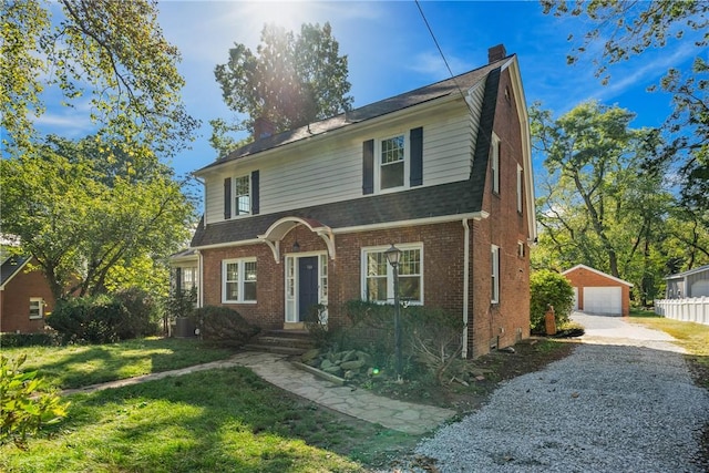 view of front facade with an outbuilding, a front yard, and a garage