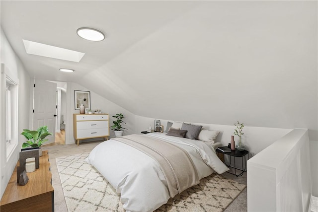 bedroom featuring light carpet and lofted ceiling with skylight