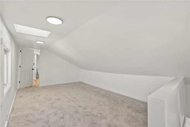 bonus room featuring light colored carpet and vaulted ceiling with skylight