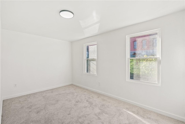 unfurnished room with plenty of natural light and light carpet