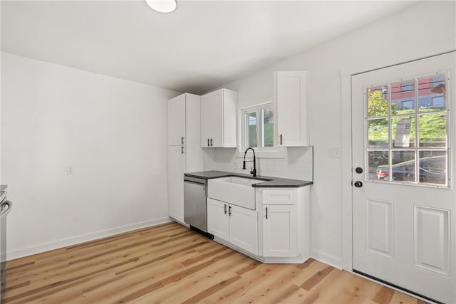 kitchen featuring white cabinets, dishwasher, light wood-type flooring, and tasteful backsplash