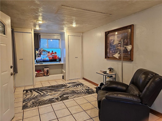 interior space featuring light tile patterned flooring and a textured ceiling