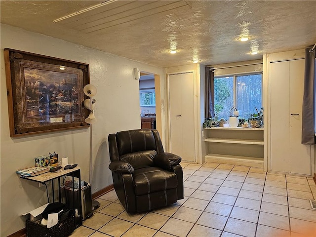 sitting room featuring light tile patterned floors and a textured ceiling