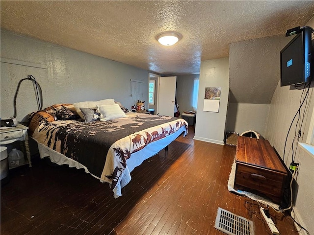 bedroom featuring dark hardwood / wood-style floors and a textured ceiling