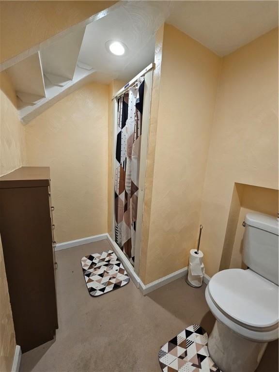 bathroom with a shower with shower curtain and toilet