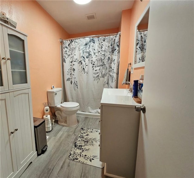 bathroom with curtained shower, vanity, wood-type flooring, and toilet