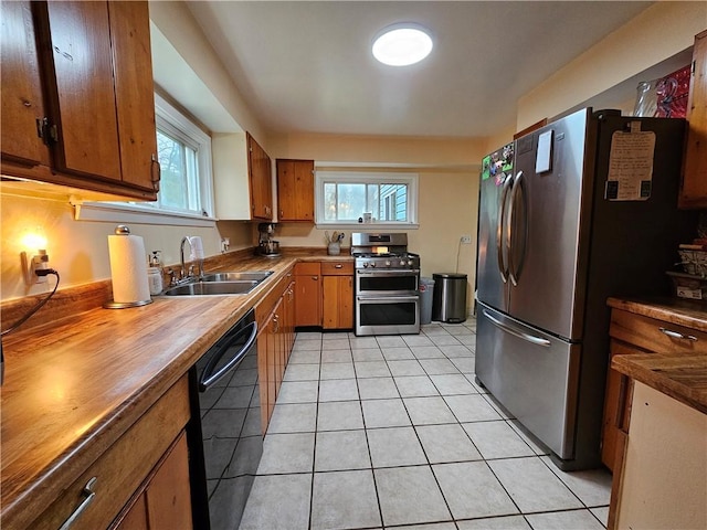 kitchen featuring sink, light tile patterned floors, stainless steel appliances, and a wealth of natural light