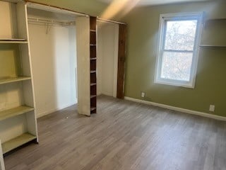 unfurnished bedroom featuring light hardwood / wood-style flooring and lofted ceiling