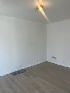 empty room featuring dark hardwood / wood-style flooring and ceiling fan