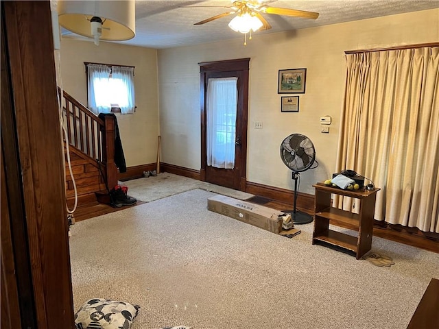 foyer featuring carpet, a textured ceiling, and ceiling fan