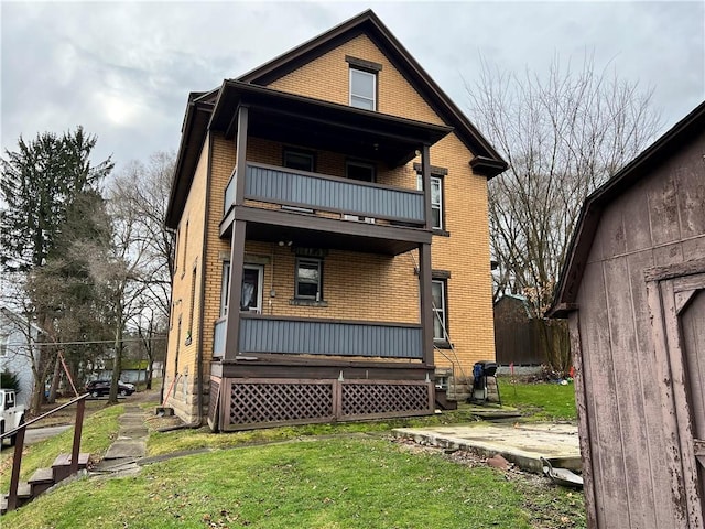 rear view of house with a yard and a balcony