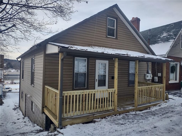 snow covered property featuring covered porch