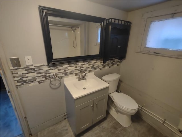 bathroom with vanity, toilet, and backsplash