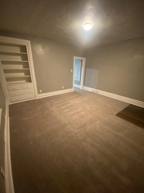 carpeted empty room featuring built in features