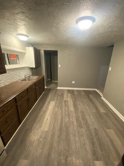 kitchen with dark hardwood / wood-style floors, sink, dark brown cabinets, and a textured ceiling