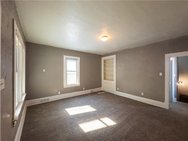 unfurnished bedroom with dark carpet