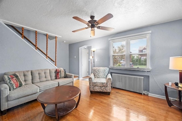 living room featuring hardwood / wood-style floors, radiator, and ceiling fan