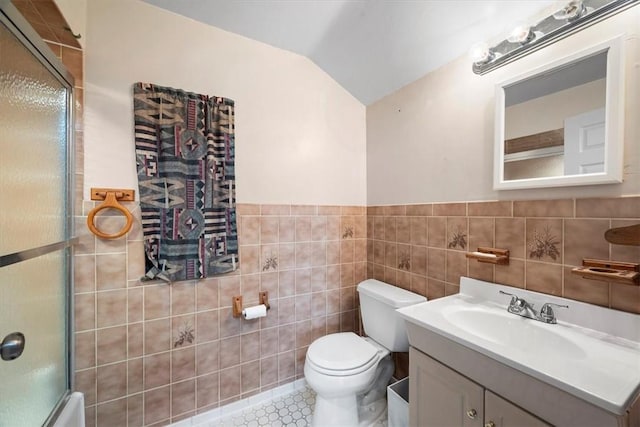 full bathroom with tile patterned floors, vanity, tile walls, toilet, and lofted ceiling