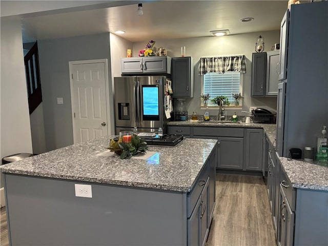 kitchen with gray cabinets, sink, a kitchen island, and stainless steel refrigerator with ice dispenser