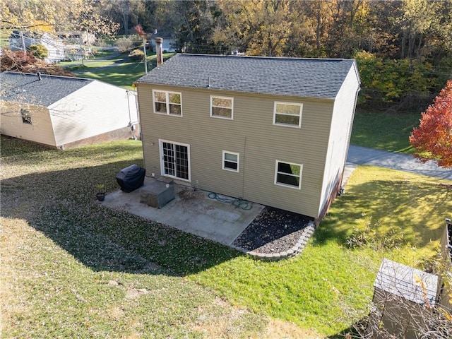 back of house featuring a lawn and a patio