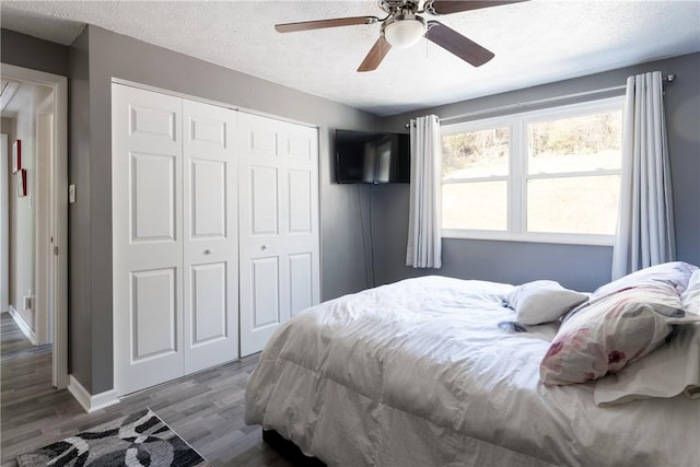 bedroom featuring hardwood / wood-style floors, ceiling fan, a textured ceiling, and a closet