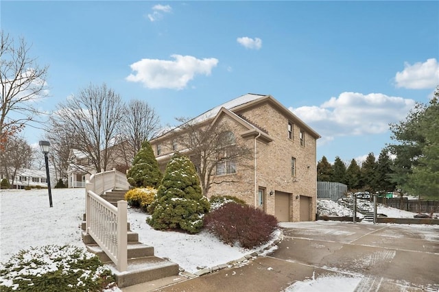 snow covered property with a garage