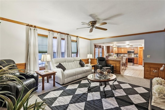 living room with ceiling fan, crown molding, and light carpet