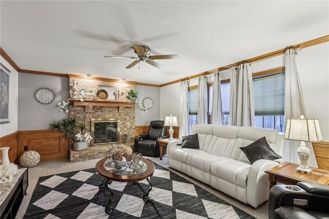 carpeted living room with ceiling fan, ornamental molding, and a brick fireplace