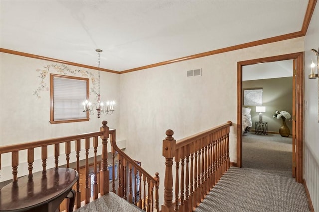 stairs with carpet floors, crown molding, and a chandelier