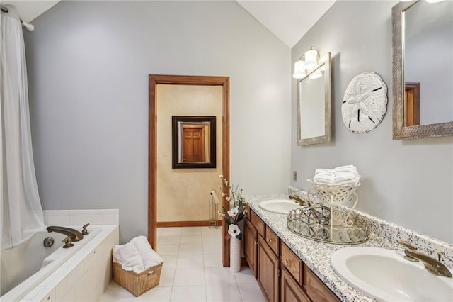 bathroom featuring tile patterned flooring, vanity, a relaxing tiled tub, and vaulted ceiling