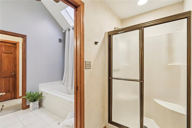 bathroom with tile patterned flooring, lofted ceiling with skylight, and plus walk in shower