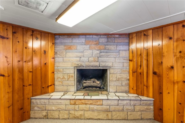 details with carpet flooring, wooden walls, and a fireplace