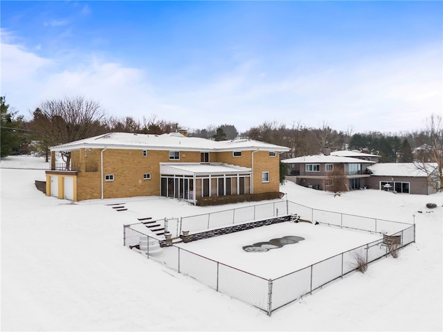 snow covered house with a sunroom