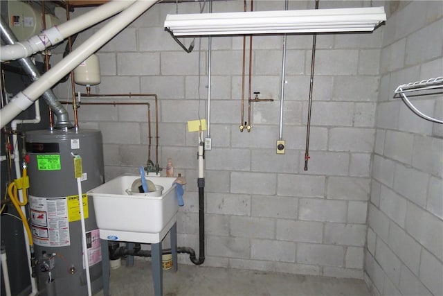 utility room with water heater and sink