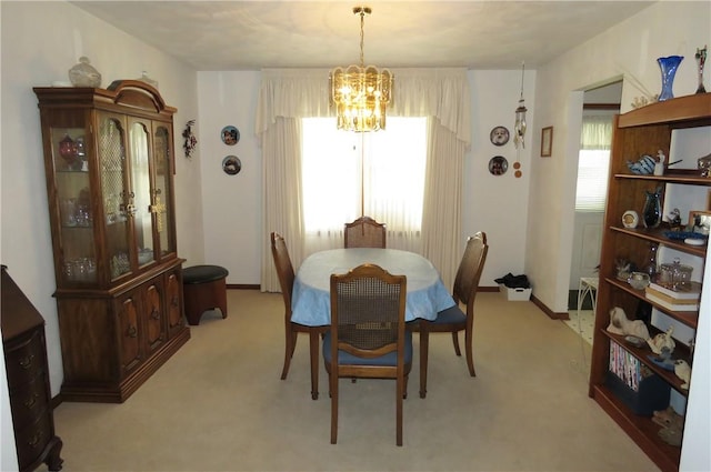 carpeted dining space featuring an inviting chandelier