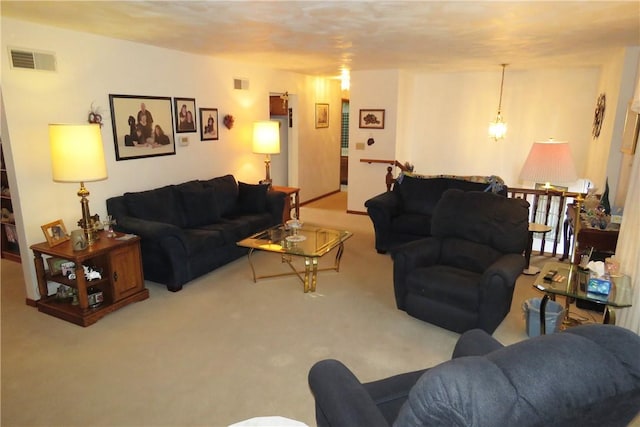 carpeted living room featuring a notable chandelier