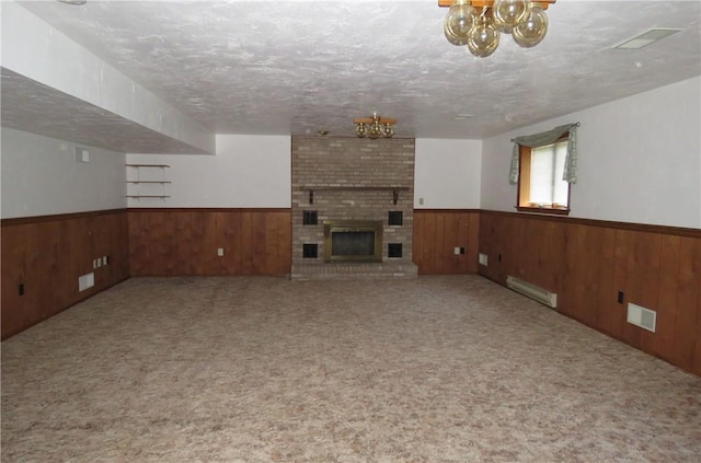 unfurnished living room featuring a textured ceiling, carpet floors, a brick fireplace, and baseboard heating