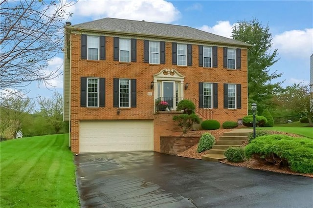 colonial home with a front lawn and a garage