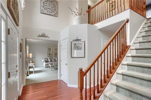 entryway with a towering ceiling and hardwood / wood-style flooring