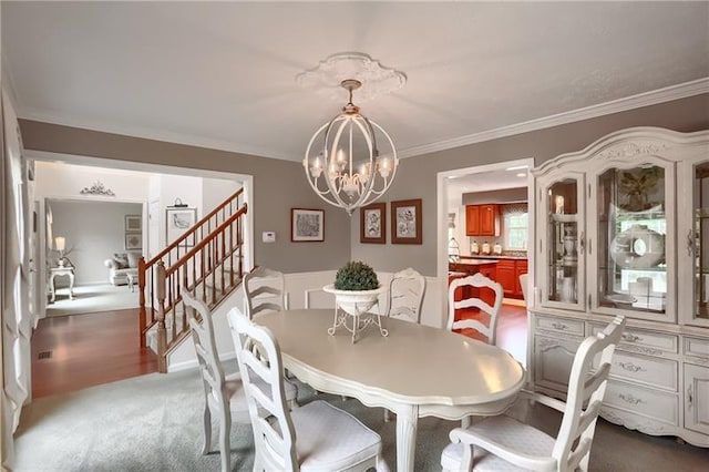 carpeted dining room with ornamental molding and a notable chandelier