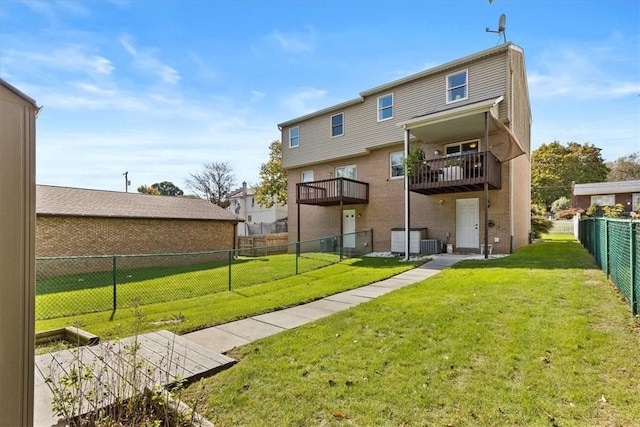 rear view of property with a lawn, a balcony, and central AC unit