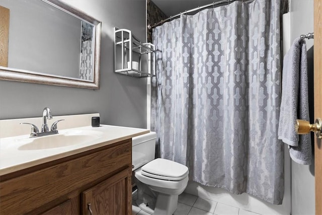 bathroom with toilet, vanity, and tile patterned floors