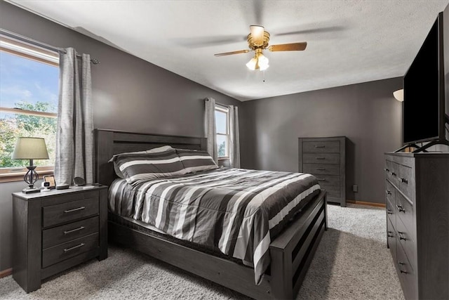 carpeted bedroom with multiple windows and ceiling fan