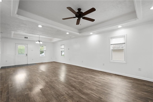 unfurnished room with ceiling fan with notable chandelier, dark hardwood / wood-style flooring, crown molding, and a tray ceiling