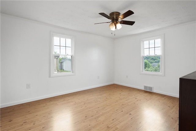 empty room featuring ceiling fan, light hardwood / wood-style floors, and crown molding